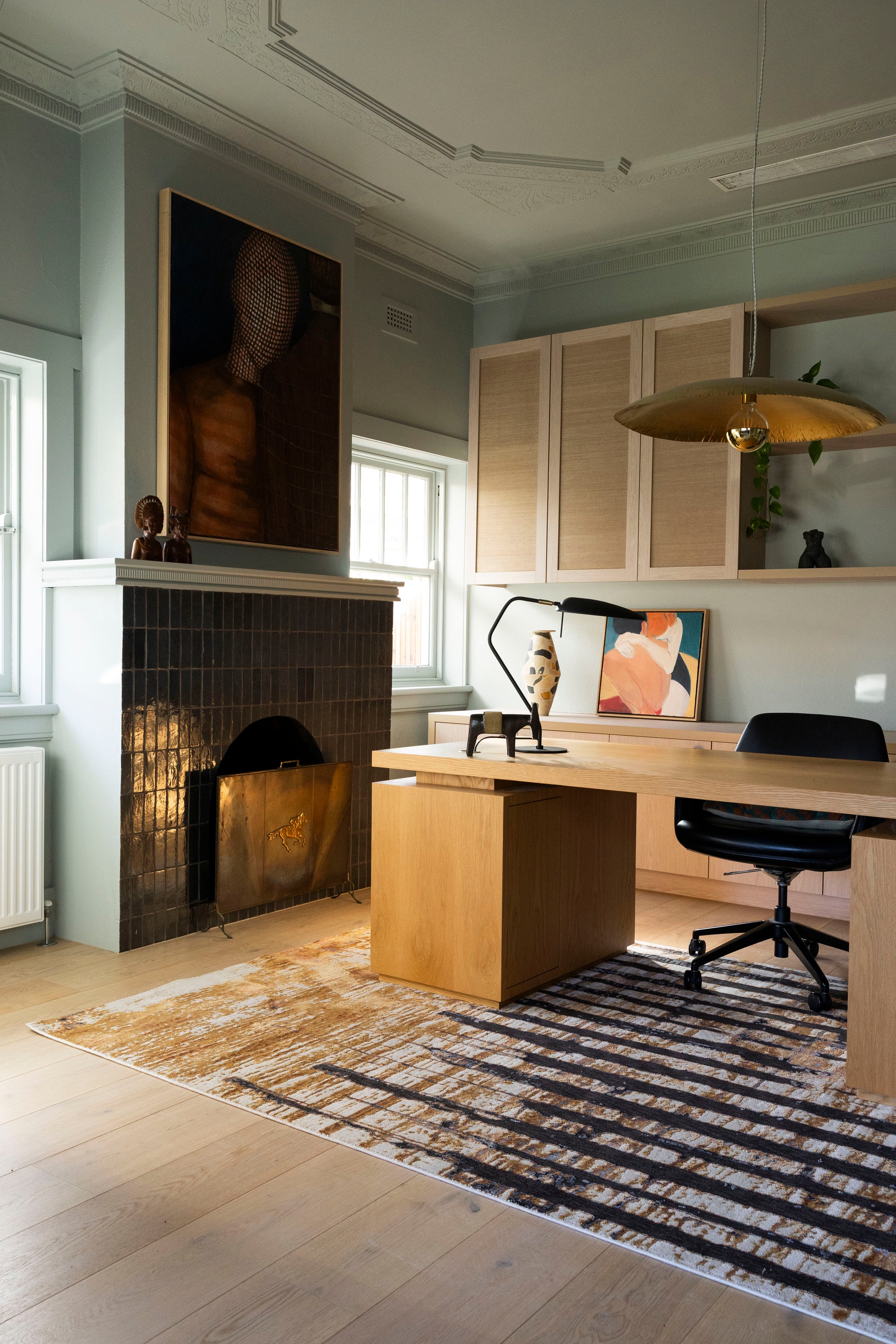Modern home office with wooden desk, chair, and decorative items on Amber Smoke Abstract Rug by Four Corners Rugs
