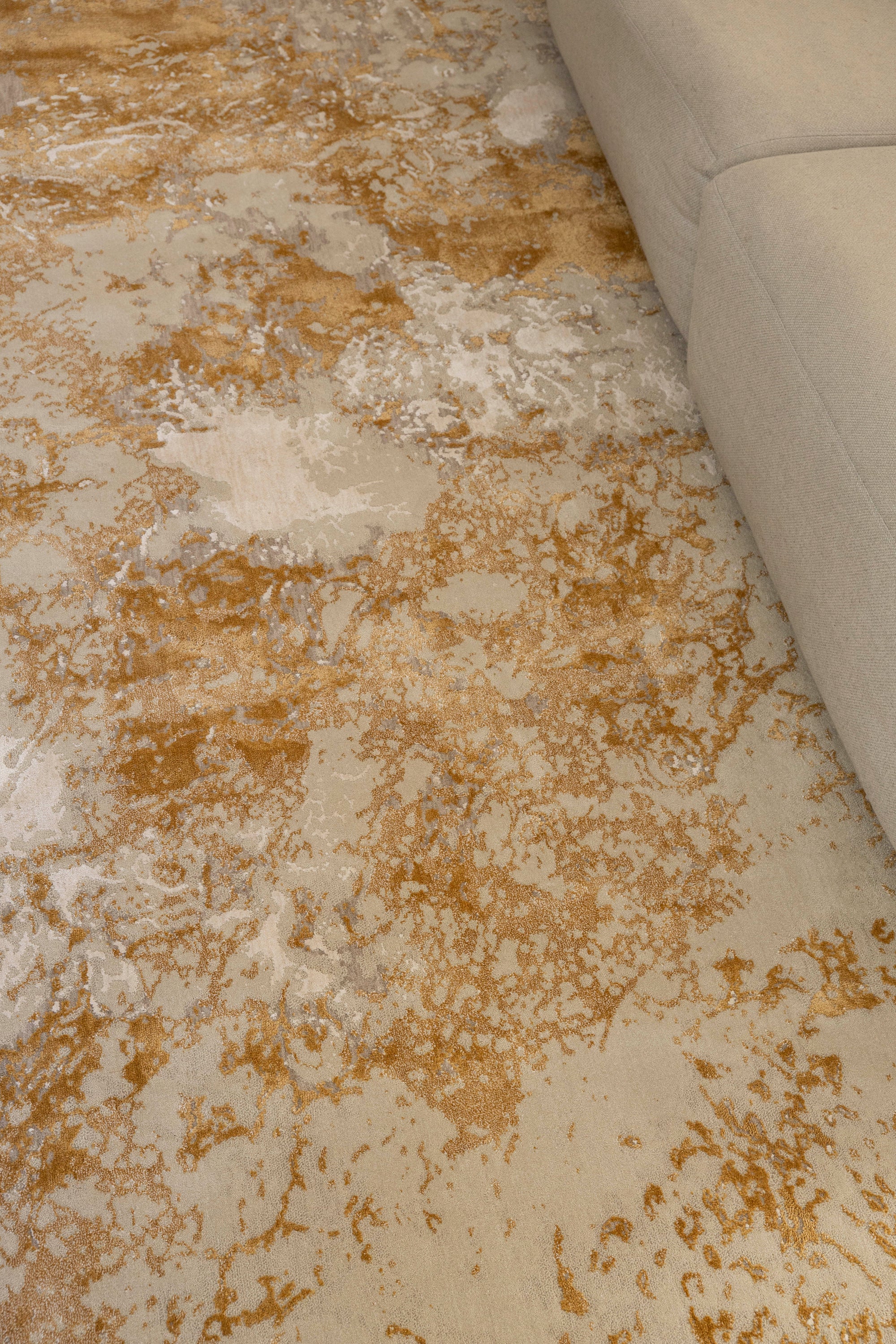 Golden Dusk Abstract Rug by Four Corners Rugs with a corner of a beige sofa visible