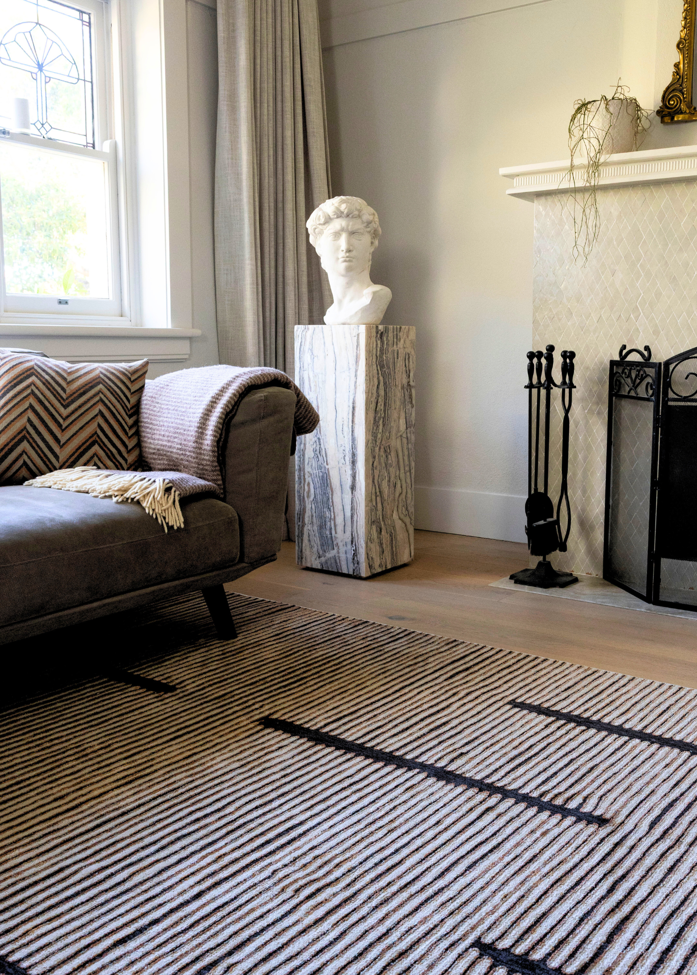 Living room with Midnight Suede Abstract Rug by Four Corners Rugs, sofa, and decorative elements.