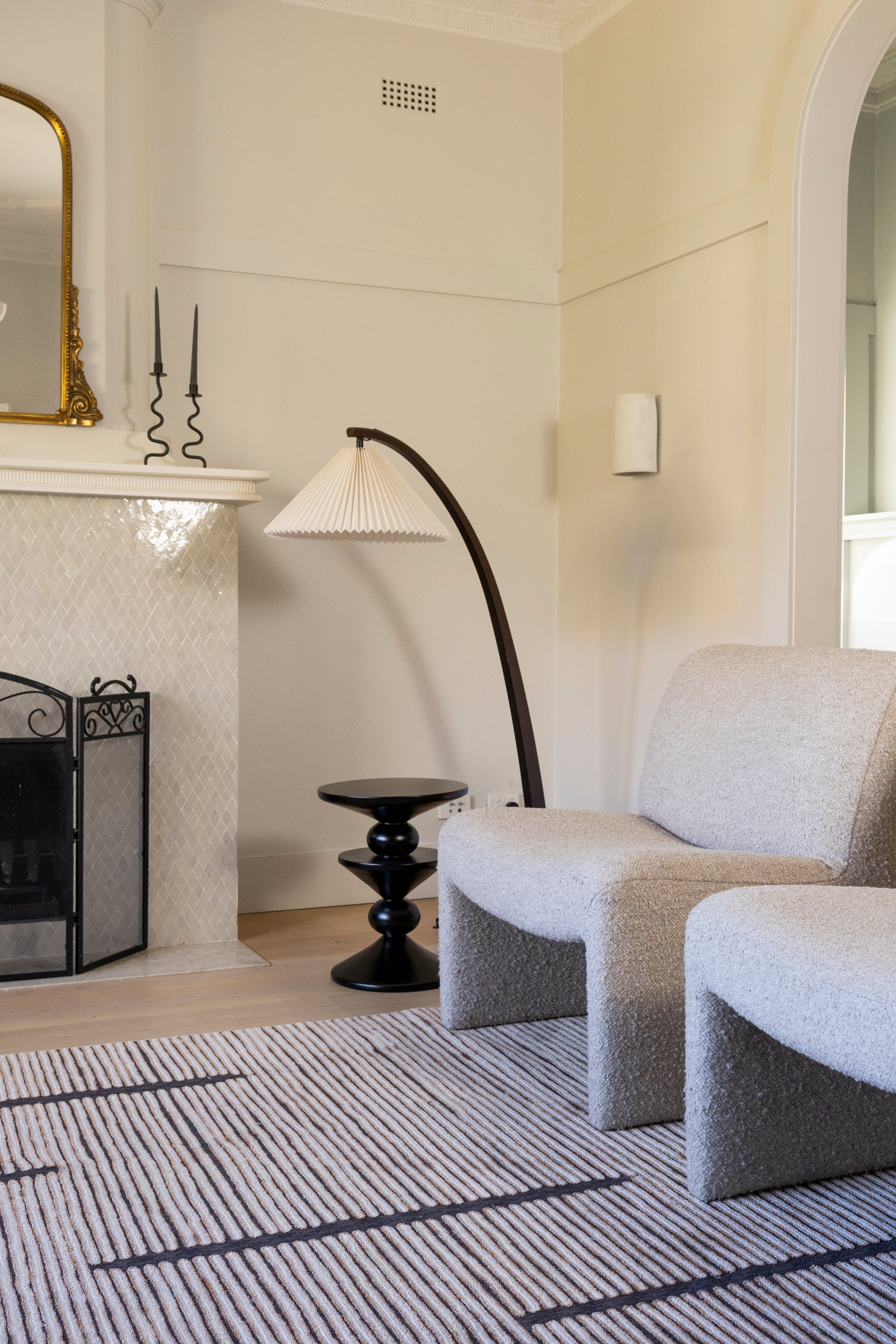 Modern living room with grey armchairs, black floor lamp, fireplace and Midnight Suede Abstract Rug by Four Corners Rugs