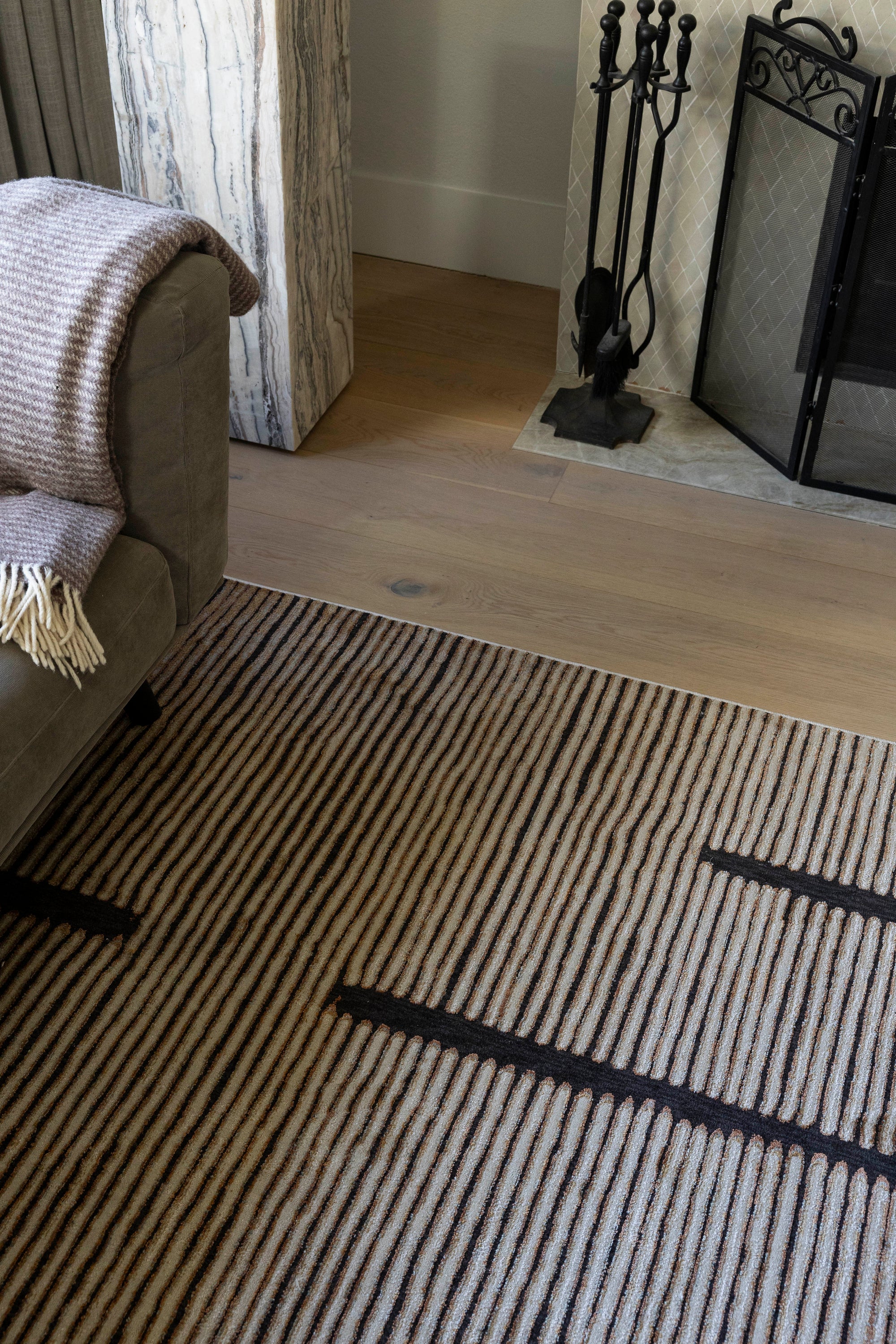 Living room with Midnight Suede Abstract Rug by Four Corners Rugs, sofa, and fireplace.