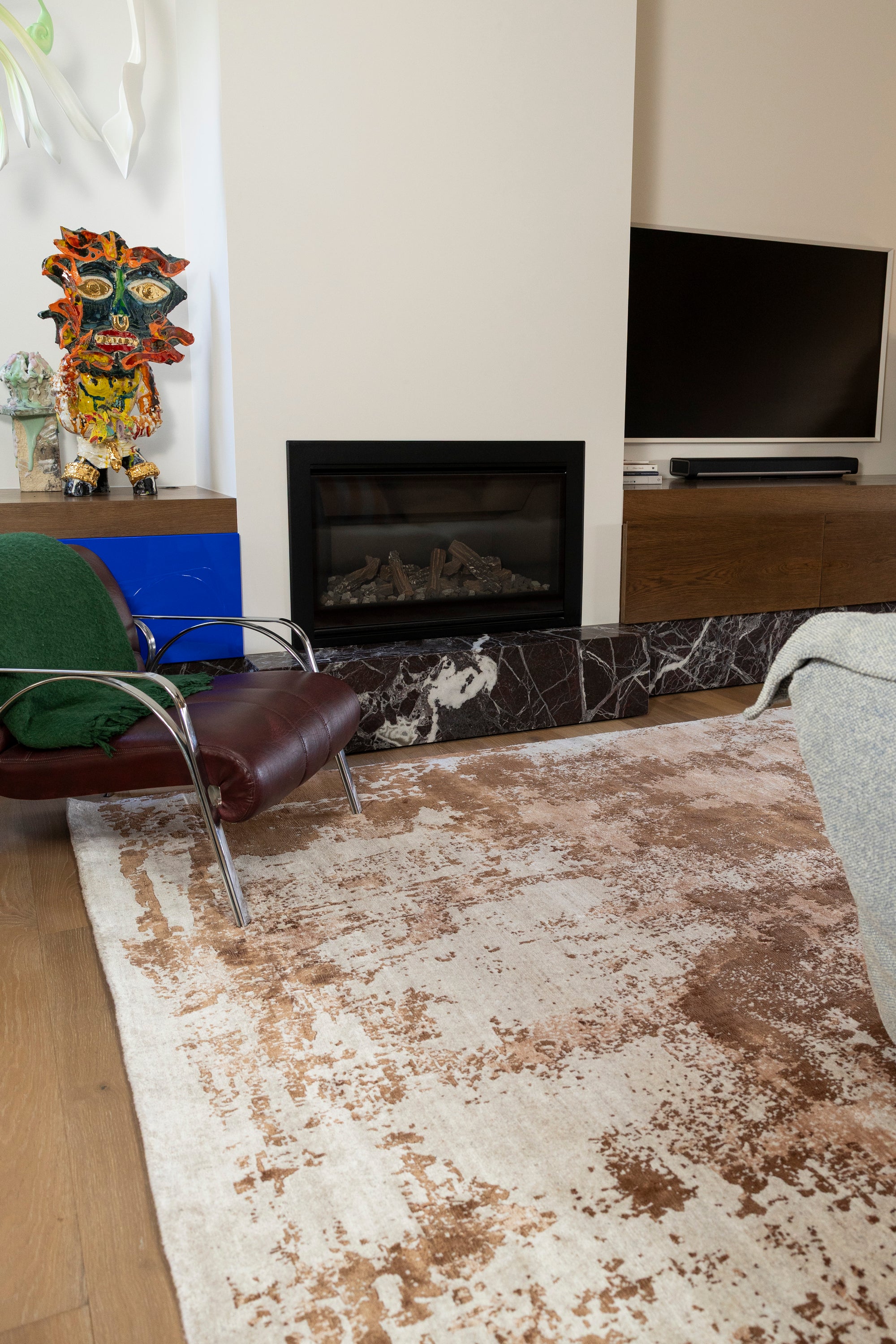 Living room with a fireplace, TV, decorative items and Blush Shadow Pink and Rust Rug By Four Corners Rugs