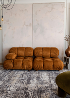 Orange sofa in a room on Charcoal Eclipse Rug by Four Corners Rugs with green velvet chair and vase 