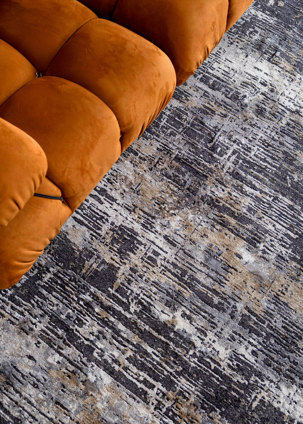 Orange sofa on Charcoal Eclipse Rug by Four Corners Rugs