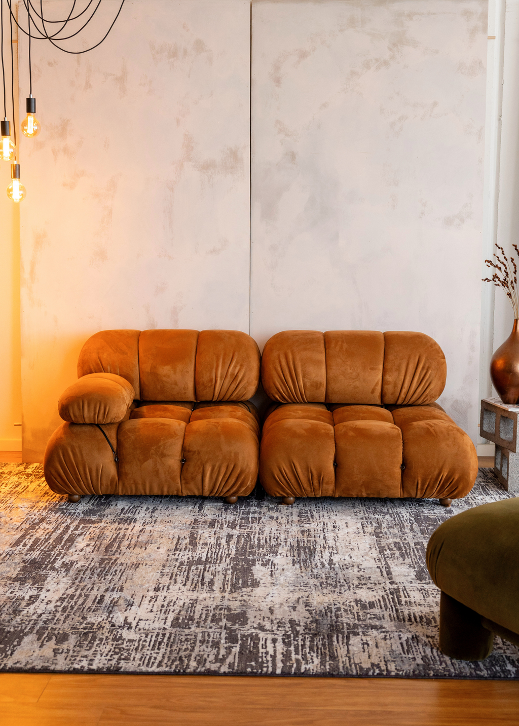 Orange sofa in a room with Charcoal Eclipse Rug by Four Corners Rugs and decorative elements.
