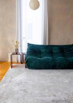 Teal sofa in a room with a small table and Christian Grey II Rug by Four Corners Rugs