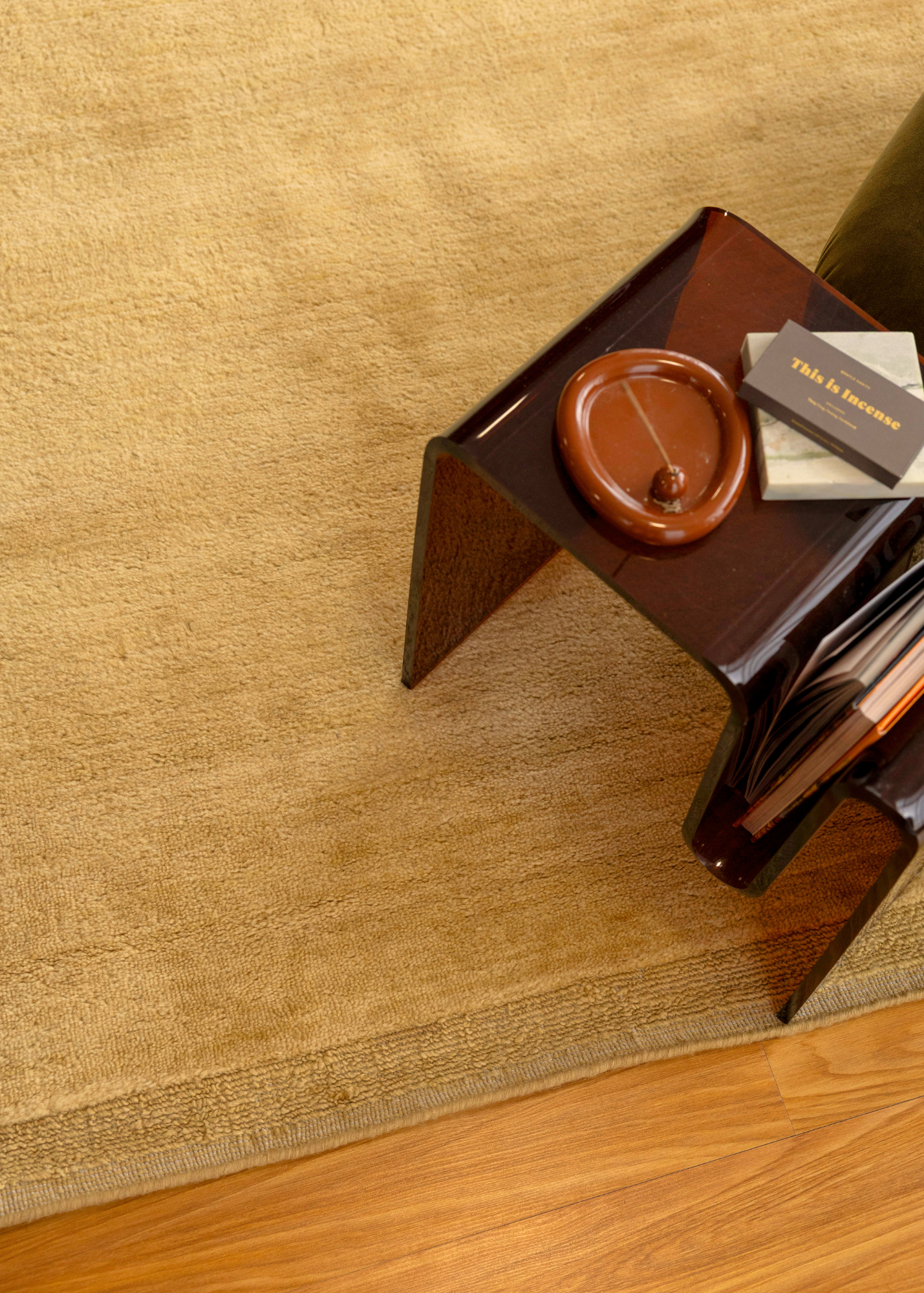 Double Border Mustard Wool Rug by Four Corners Rugs with a brown side table