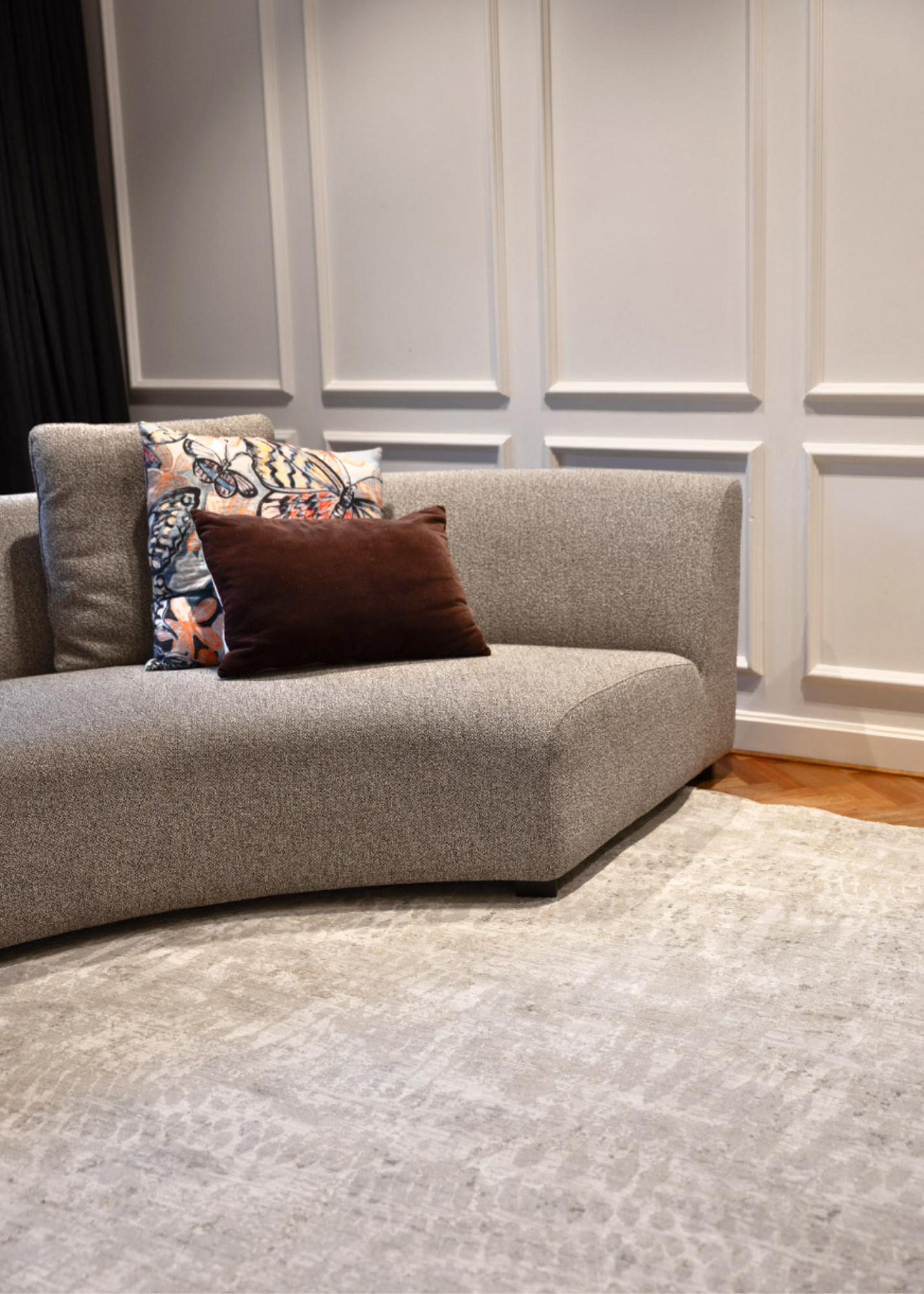 Gray sofa with decorative pillows on a Fossil Beige and Grey Rug by Four Corners Rugs