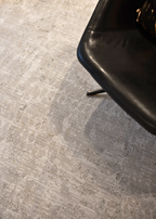 Close-up of a black chair leg Fossil Beige and Grey Rug by Four Corners Rugs