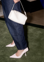 Person wearing white high-heeled shoes on Green and Green Border Rug by Four Corners Rugs