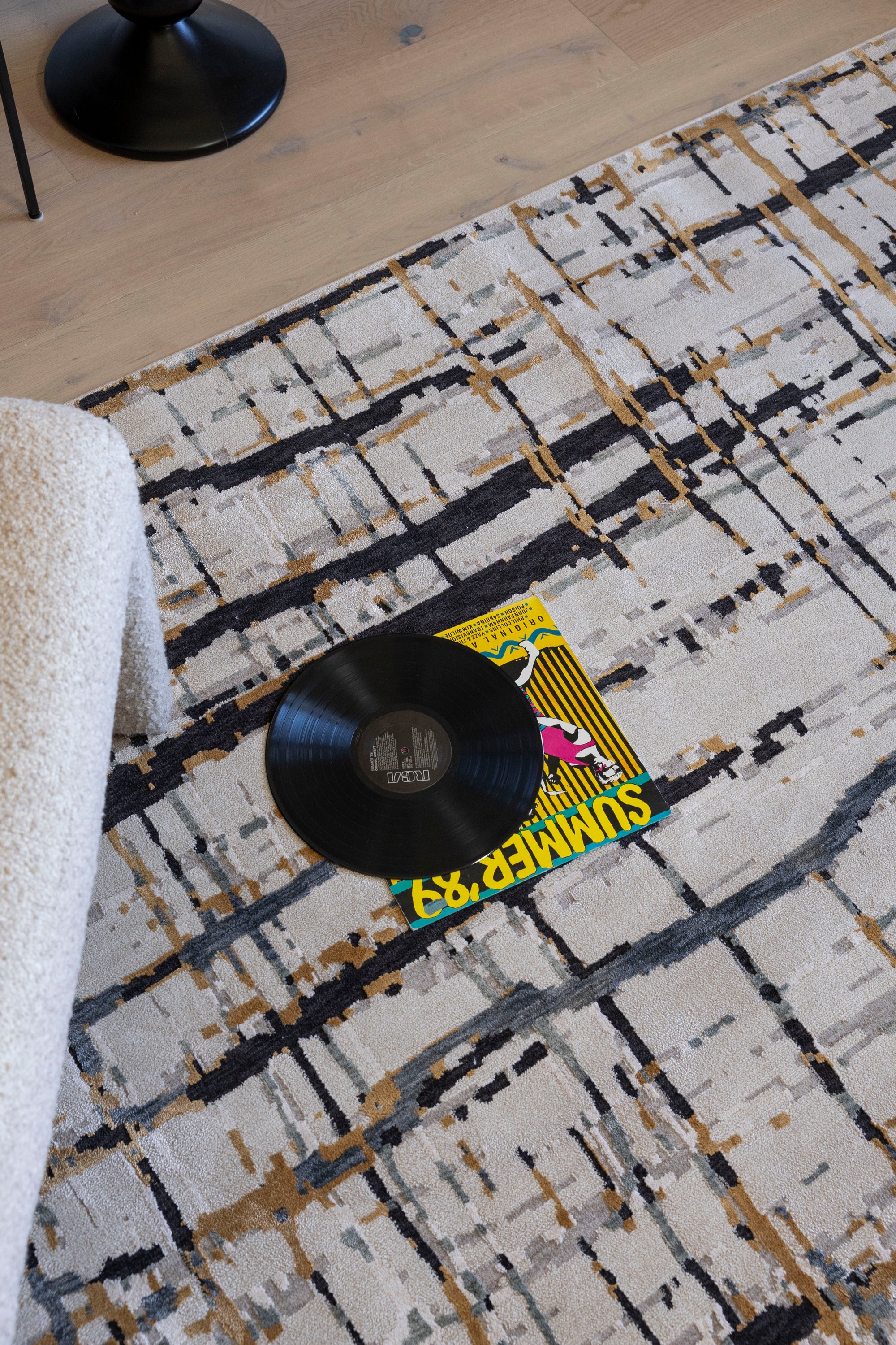 Vinyl record and cover on Moonlit Bloom Abstract Rug by Four Corners Rugs