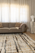 Living room with a grey sofa, Moonlit Bloom Abstract Rug by Four Corners Rugs, and decorative elements.