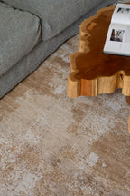 Living room with a wooden coffee table and grey sofa on Nude Contrast Gold and Brown Rug By Four Corners Rugs