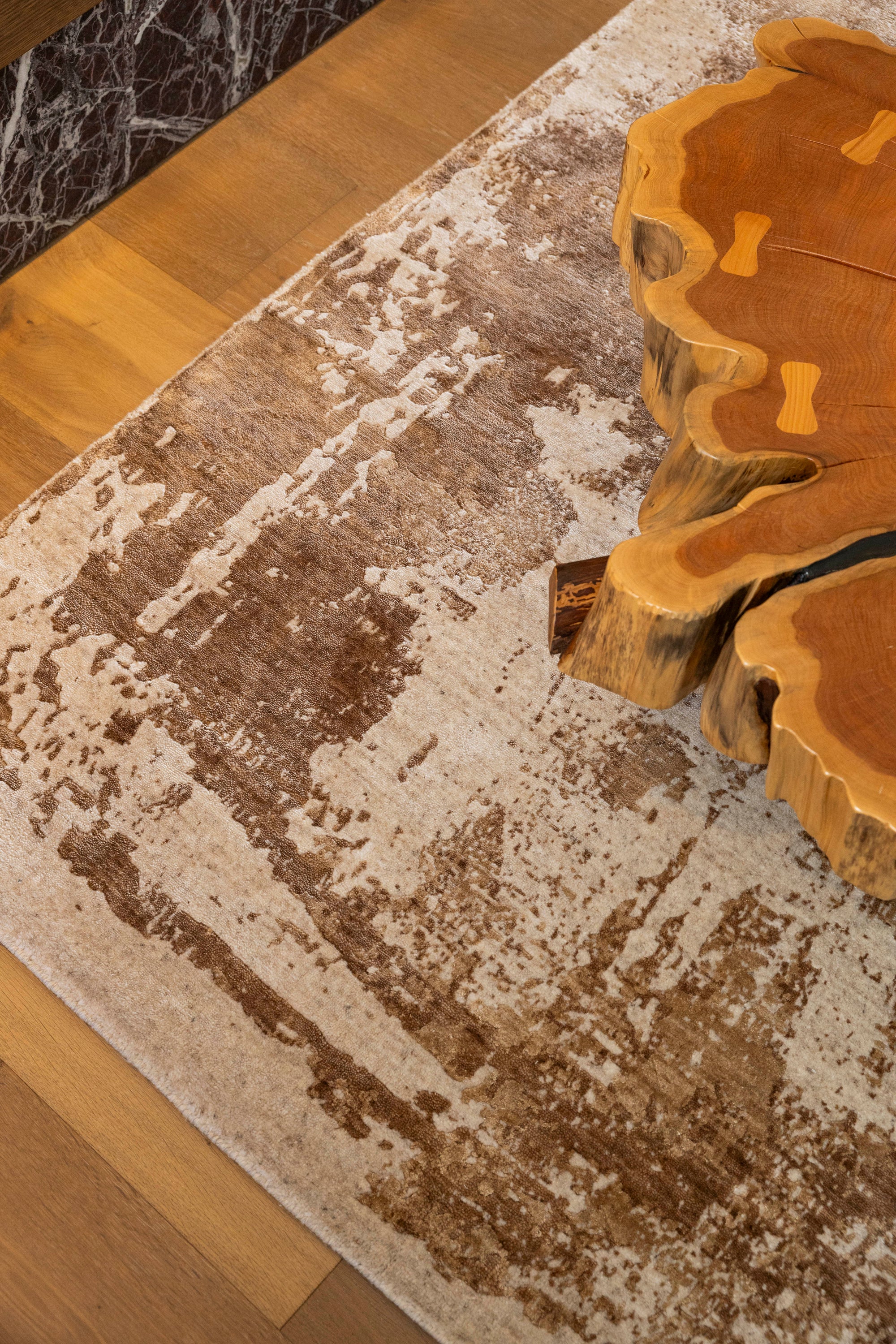 Nude Contrast Gold and Brown Rug By Four Corners Rugs with a wooden coffee table in the corner