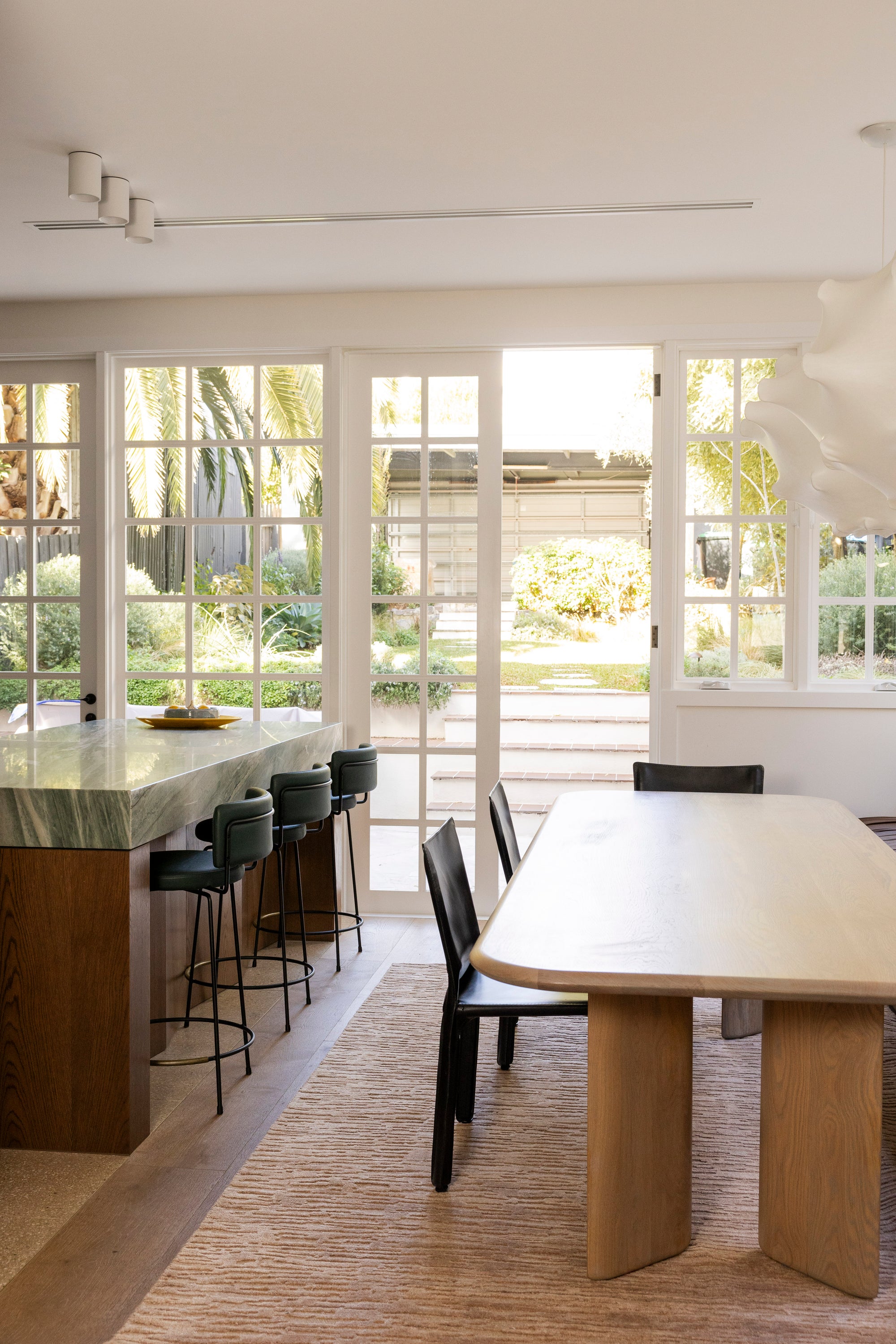 Modern kitchen with a dining table and chairs near large windows on Oceana Dusty Rose by Four Corners Rugs