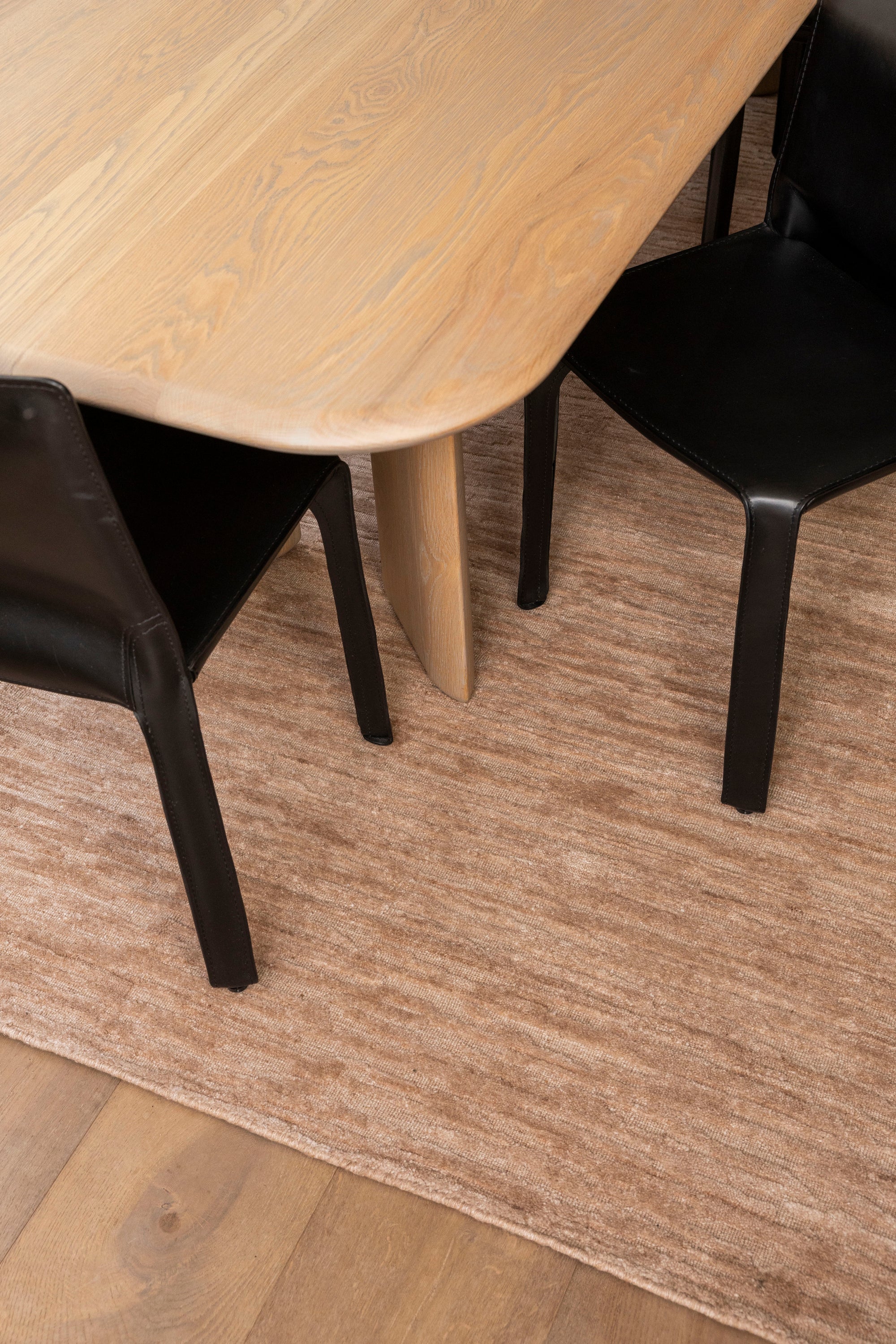 Wooden table with black chairs on Oceana Dusty Rose by Four Corners Rugs