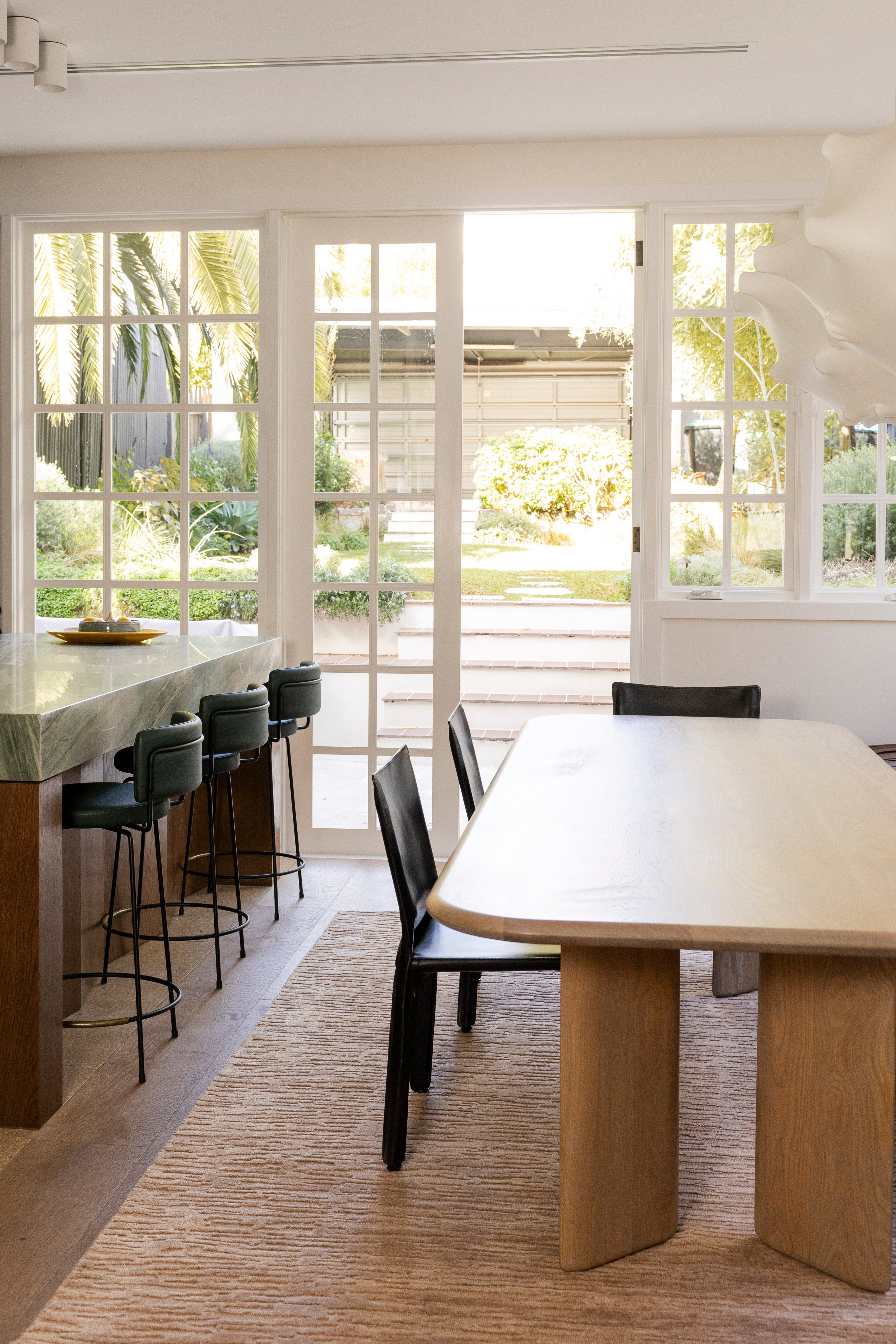 Modern kitchen with a dining table and chairs near large windows on Oceana Dusty Rose by Four Corners Rugs 