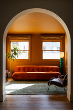 Living room with orange sofa, window, archway, plant and Oceana Forrest Green