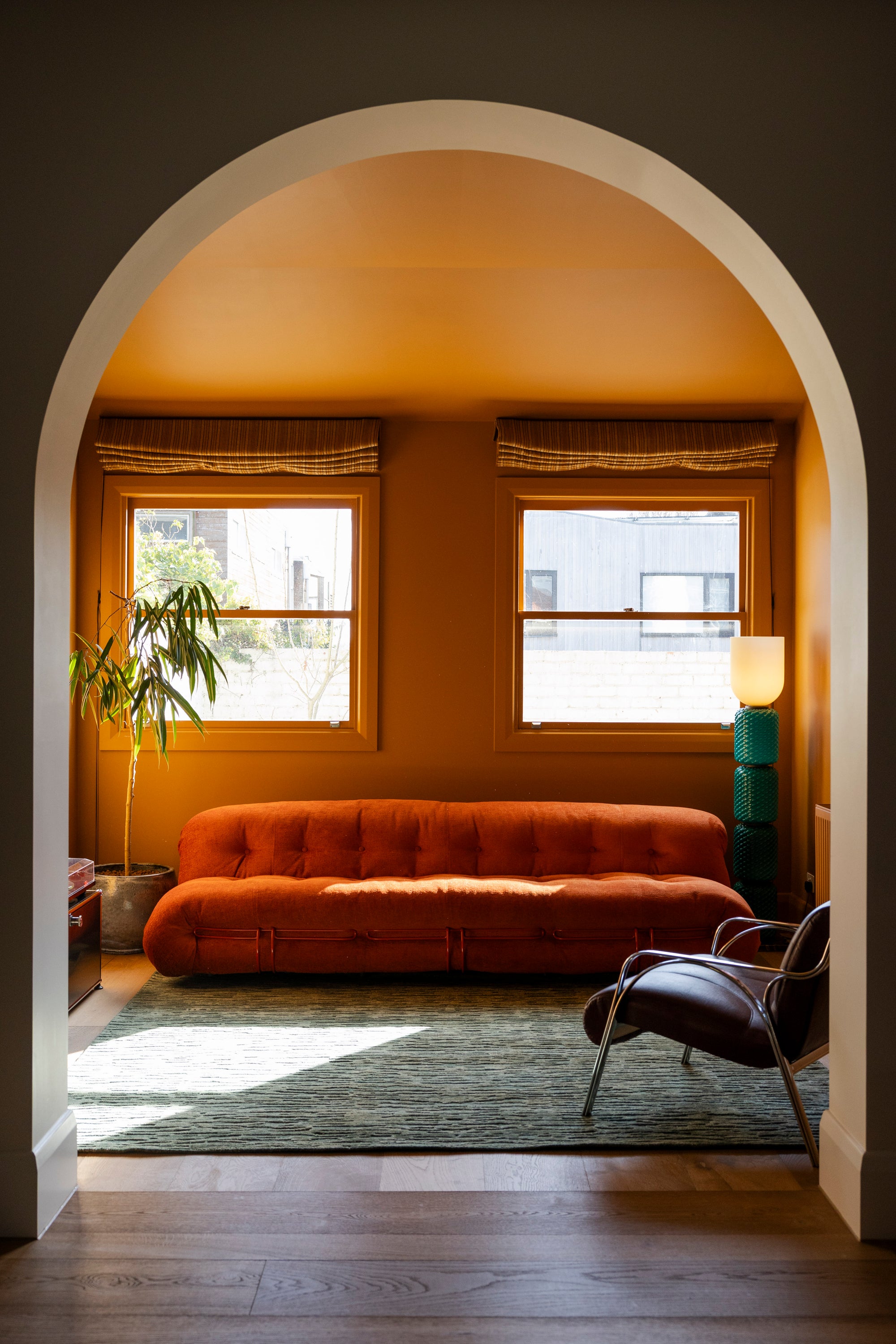 Living room with orange sofa, window, archway, plant and Oceana Forrest Green
