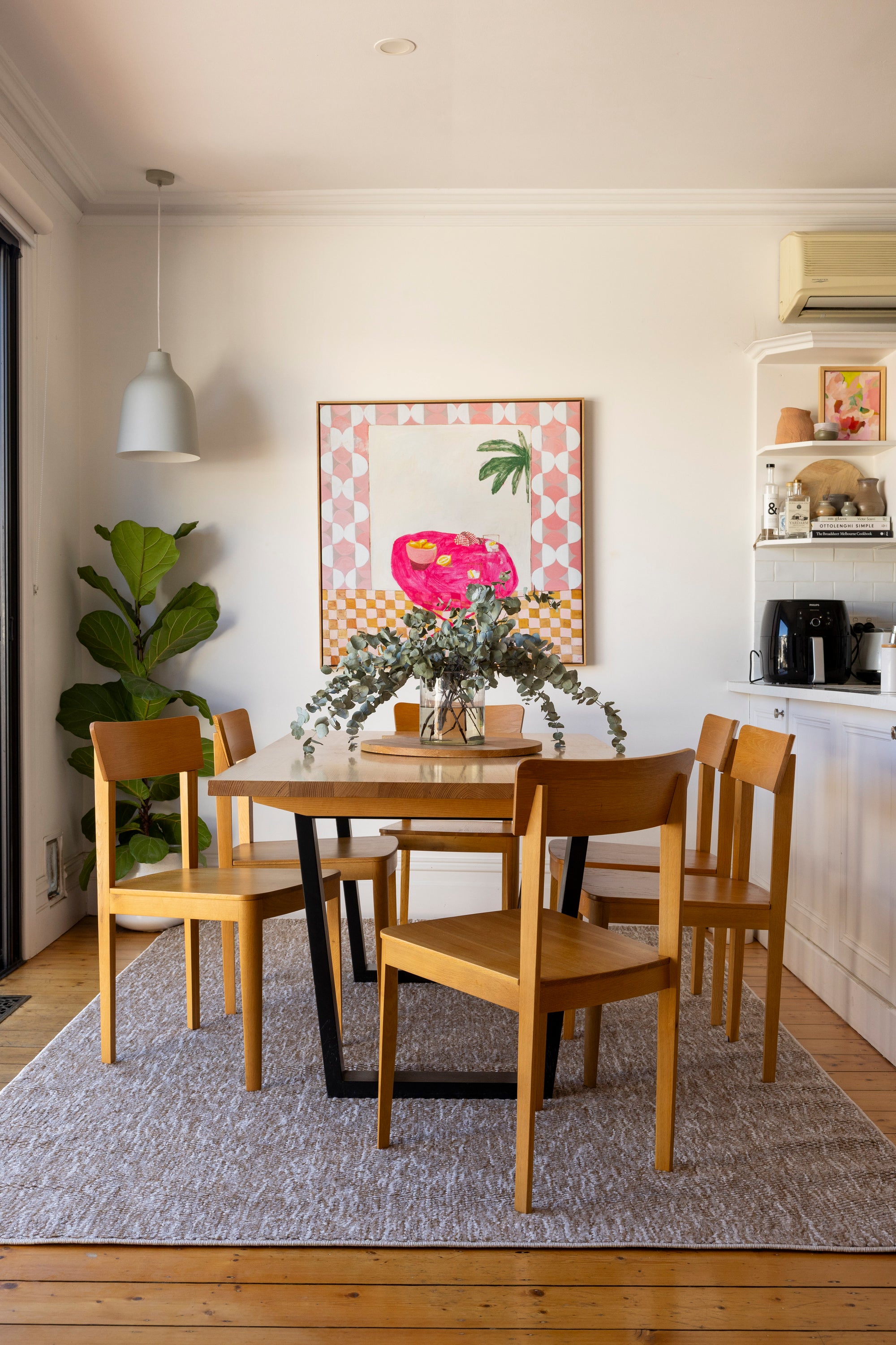 Dining area with wooden table and chairs on Pebbles Beige by Four Corners Rugs