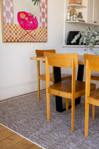 Dining area with wooden table and chairs on Pebbles Beige by Four Corners Rugs