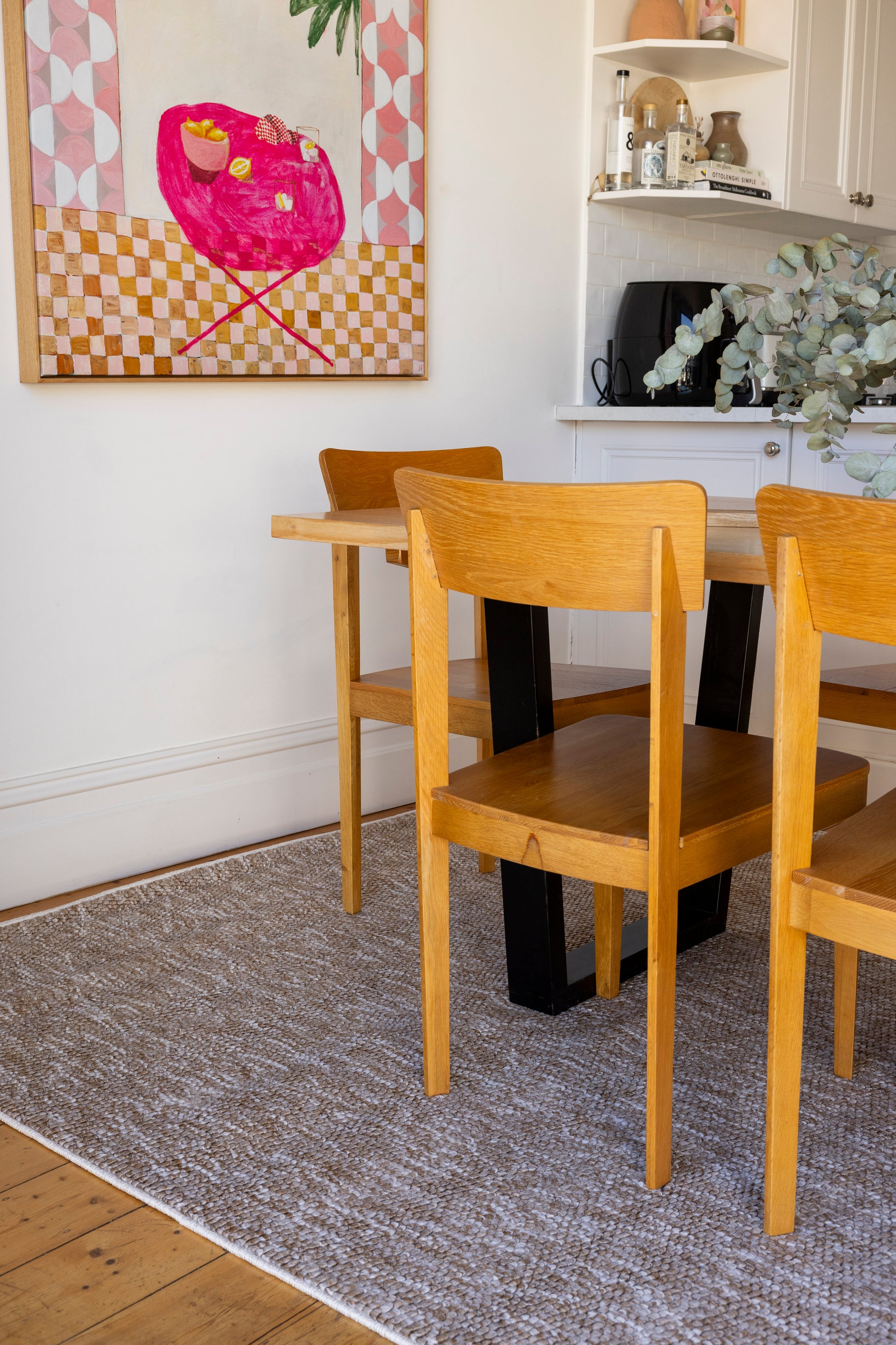 Dining area with wooden table and chairs on Pebbles Beige by Four Corners Rugs