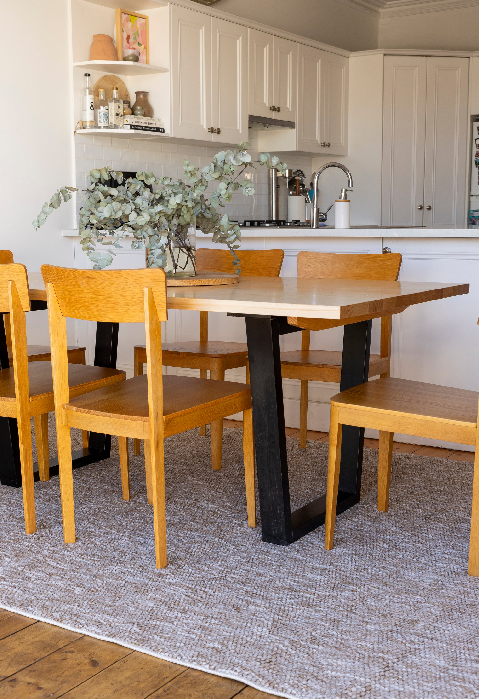 Dining area with wooden table and chairs on Pebbles Beige by Four Corners Rugs