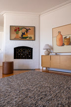 Living room with a fireplace, Pebbles Brown and Black by Four Corners Rugs, and wall art