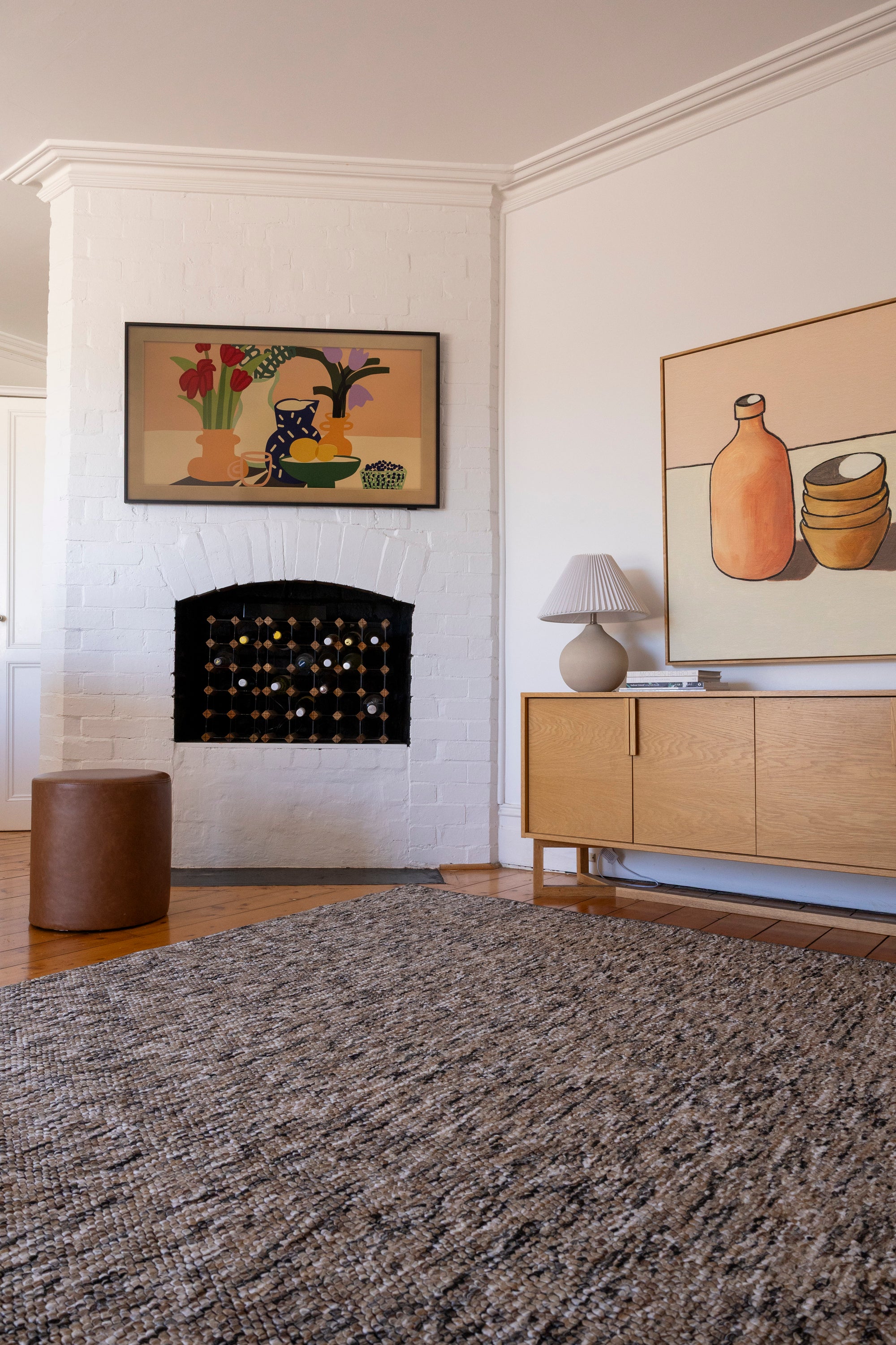 Living room with a fireplace, Pebbles Brown and Black by Four Corners Rugs, and wall art