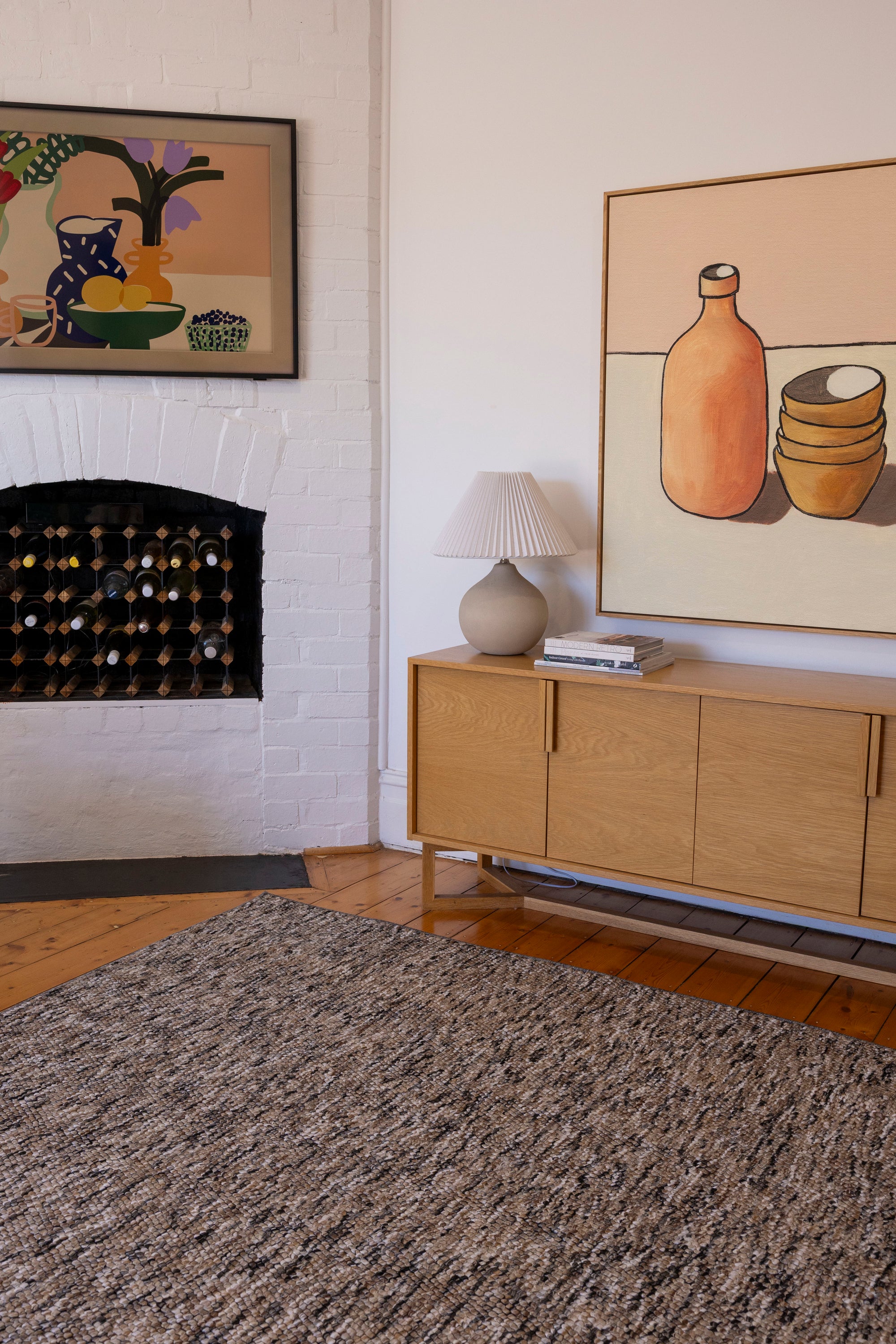 Living room with wooden sideboard, Pebbles Brown and Black by Four Corners Rugs, and wall art