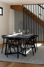 Modern dining area with black table and chairs in a home setting on Pebbles Light Grey by Four Corners Rugs