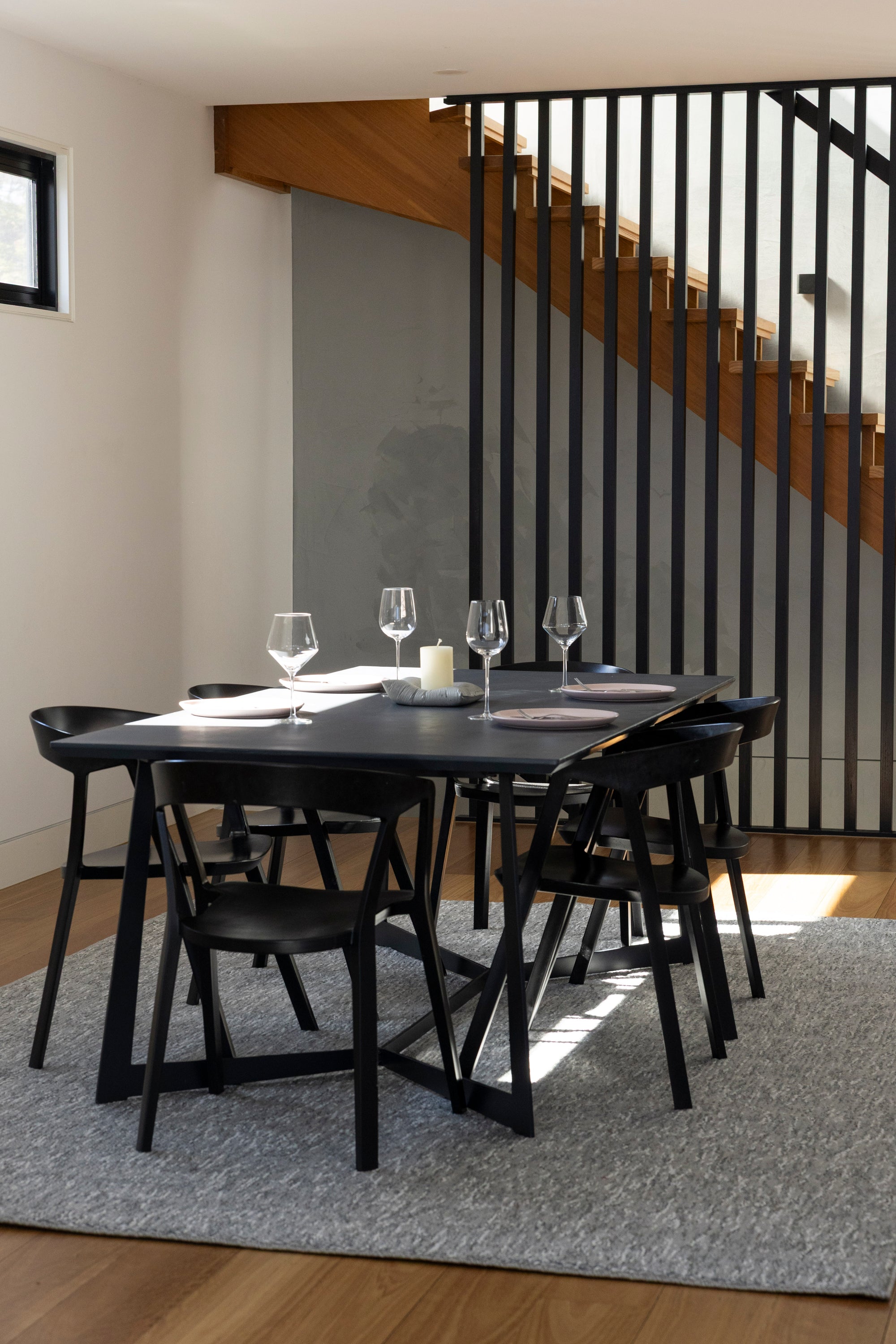 Modern dining area with black table and chairs in a home setting on Pebbles Light Grey by Four Corners Rugs