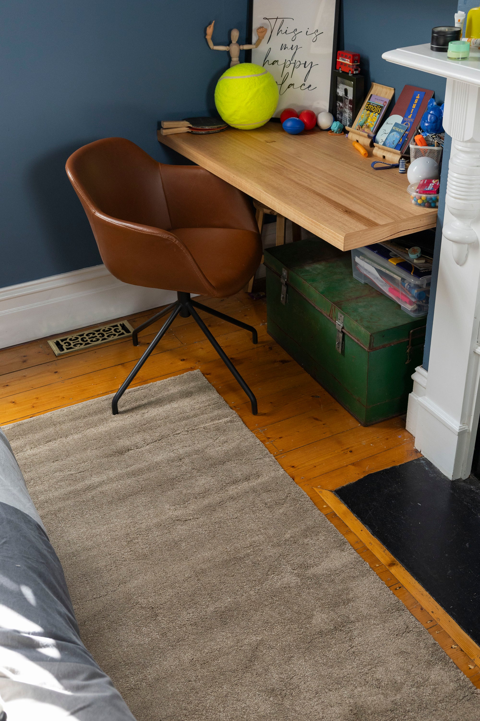 Small home office with a wooden desk, brown chair and Plush Brown Rug by Four Corners Rugs