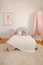 Children's bedroom with a bed, pink canopy and Plush Cream Rug by Four Corners Rugs
