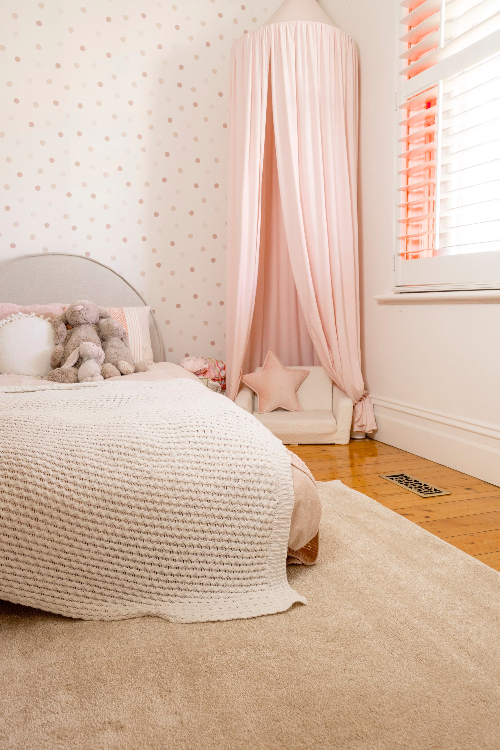 Bedroom with a canopy over the bed, soft lighting, neutral colours and Plush Cream Rug by Four Corners Rugs