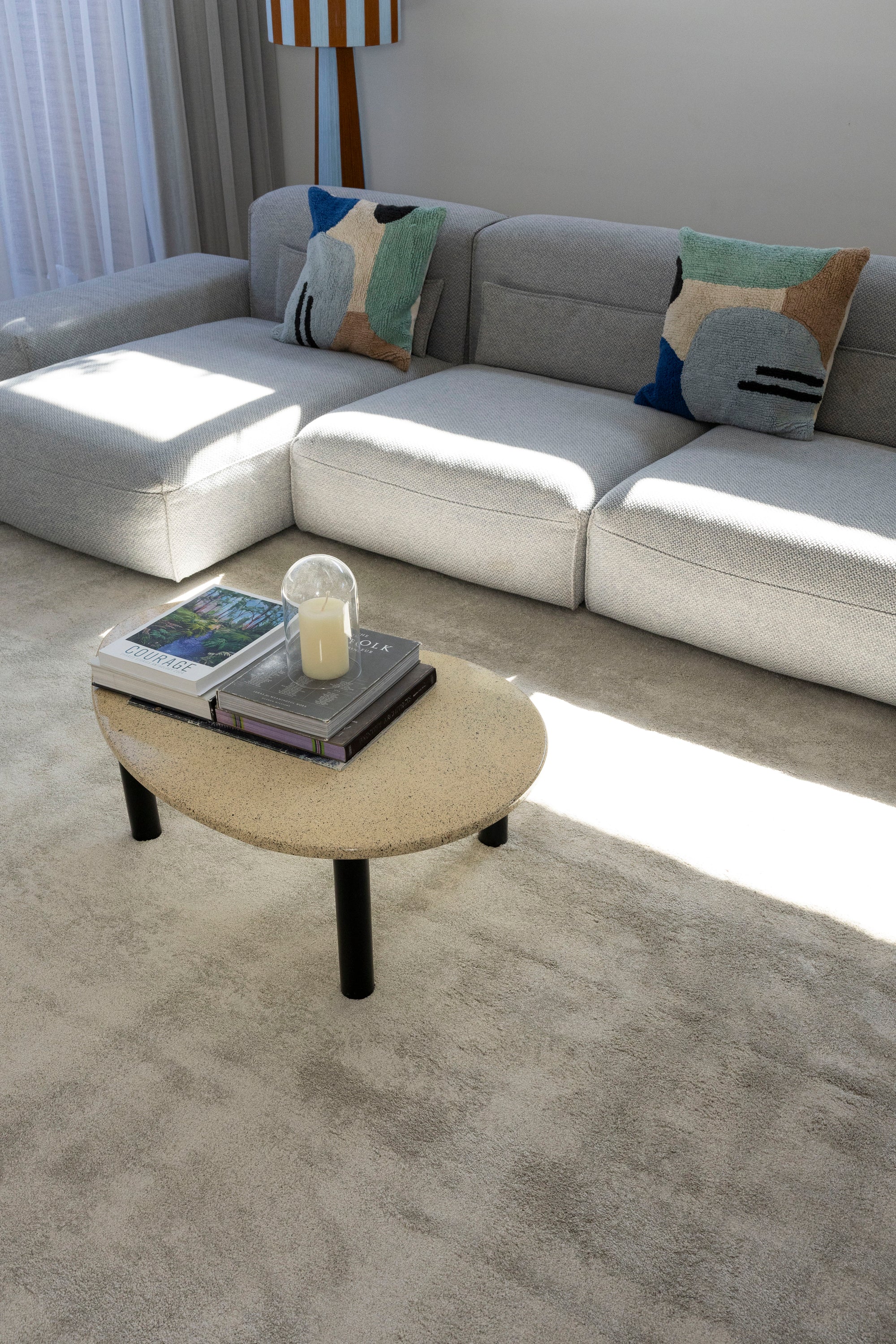 Grey sectional sofa with colorful pillows on Plush Light Grey Rug by Four Corners Rugs