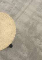 Round beige stone table on Plush Light Grey Rug by Four Corners Rugs
