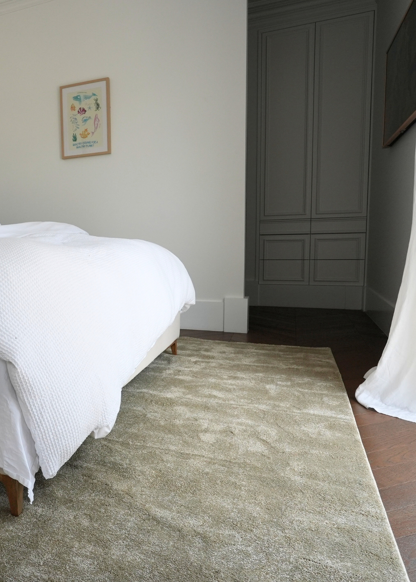 Bedroom with a bed, Plush Olive Green rug by Four Corners Rugs, and wardrobe.