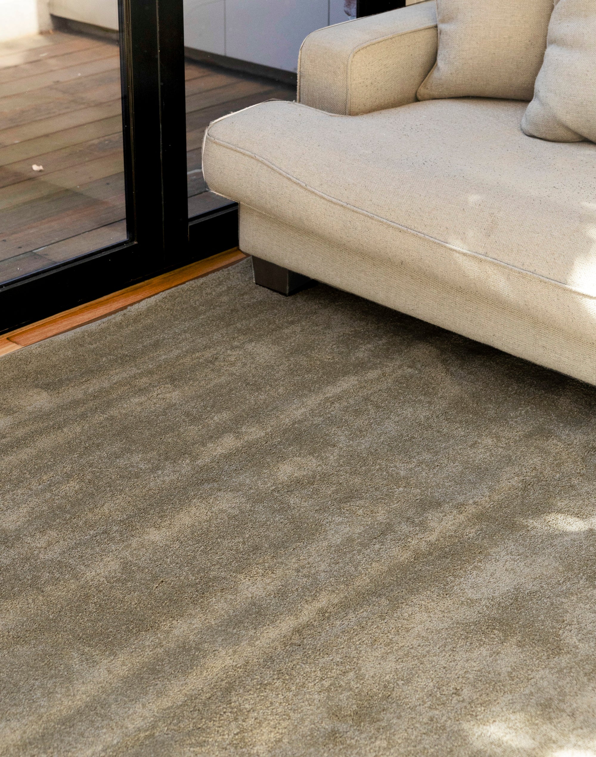 Plush Olive Green Rug by Four Corners Rugs with a beige sofa in the background
