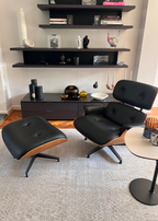 Modern black lounge chair and ottoman in a living room with shelves and Python Natural Base Rug by Four Corners Rugs