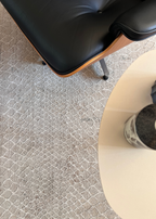 Close-up of a black office chair on Python Natural Base Rug by Four Corners Rugs