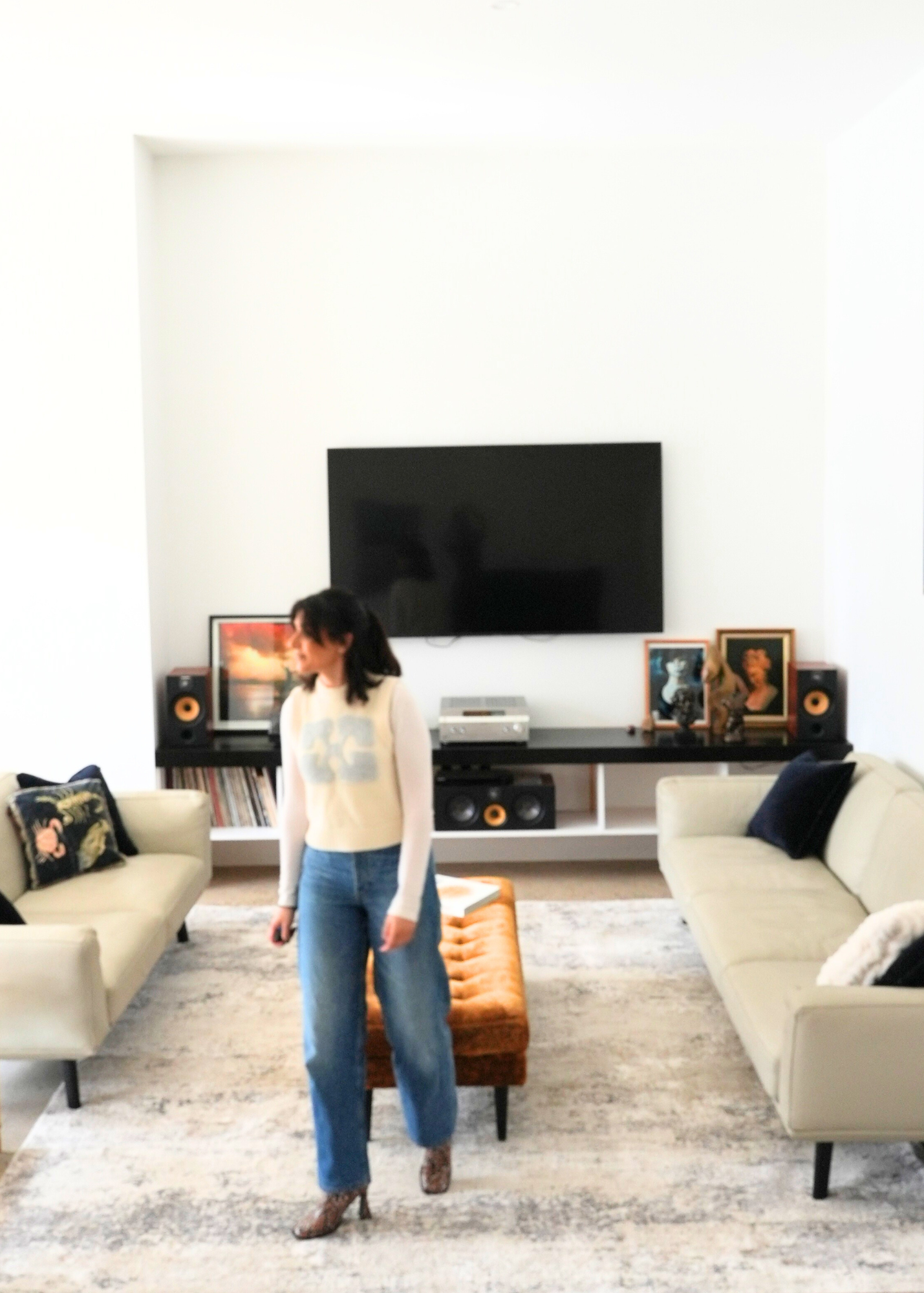 Talla standing in a modern living room with beige sofas and Silver Mist by Four Corners Rugs 