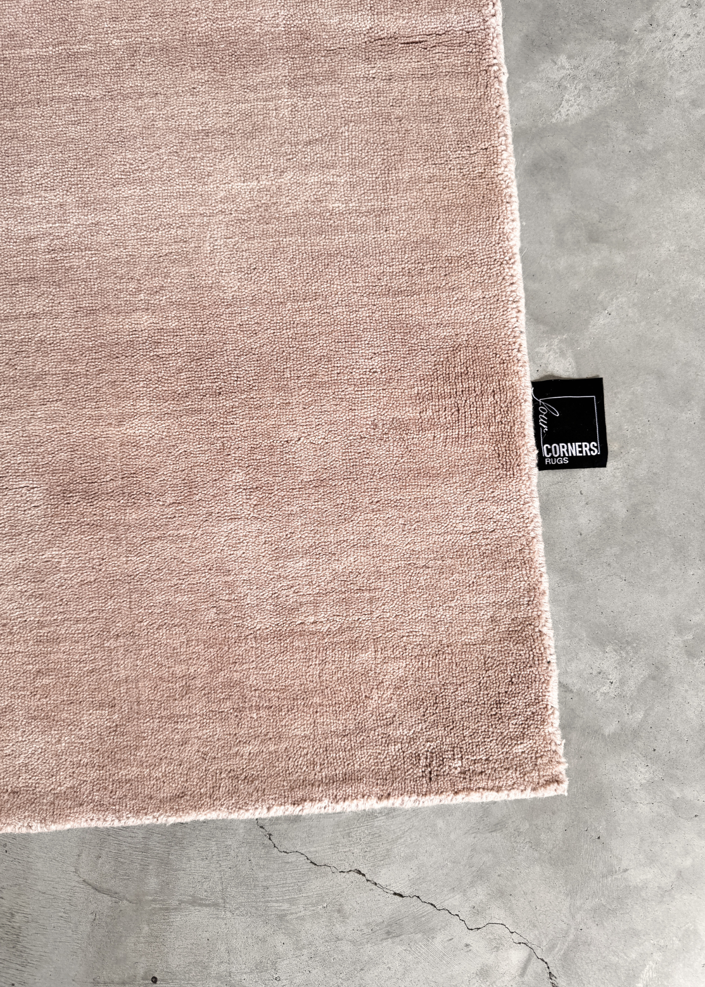 Texture Wool Blush Pink Rug Handmade rug on a concrete floor with four corners rugs tag