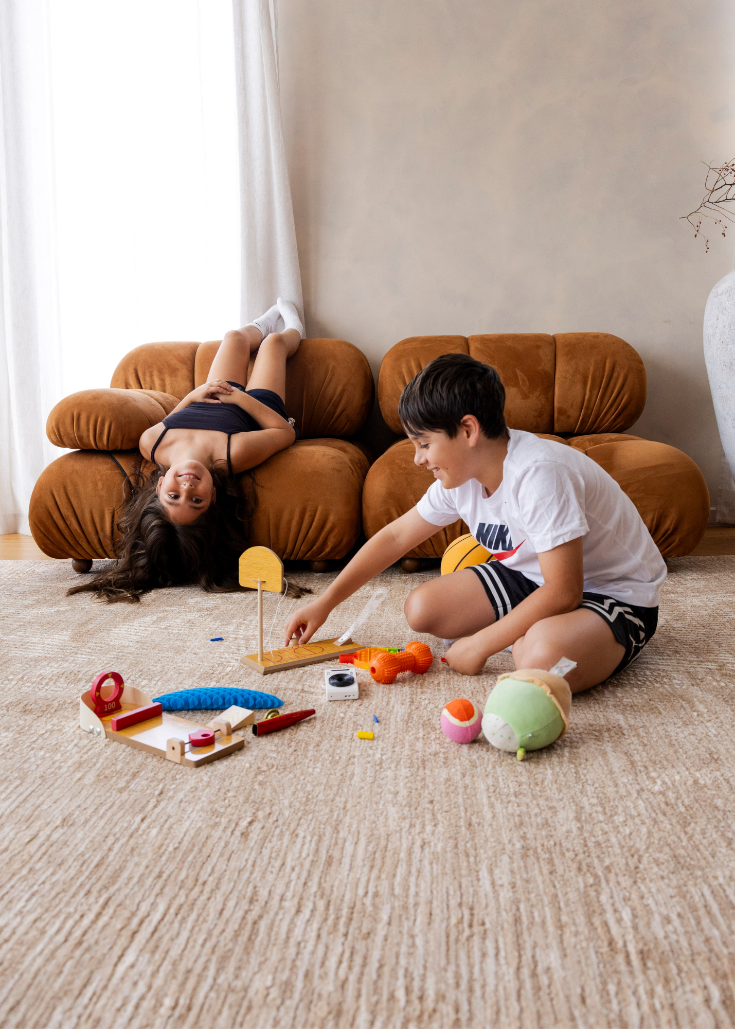 Two children playing with toys on Trinity Biscuit Rug by Four Corners Rugs in a living room