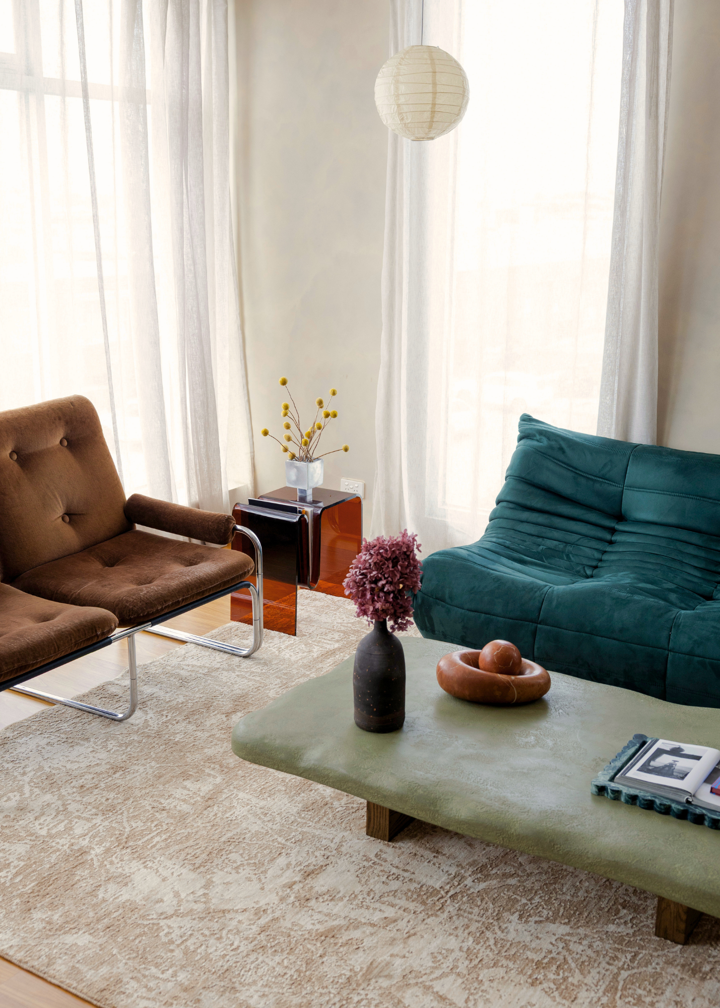 Modern living room with brown and teal sofas, a coffee table, and decorative elements on Trinity Floral Biscuit Rug by Four Corners Rugs