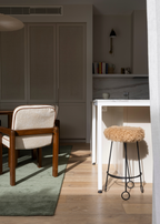Chair and stool in a room with neutral decor with Wool Texture Green Rug