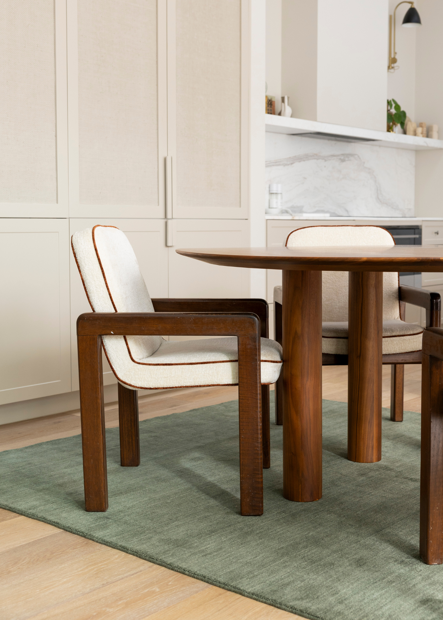 Dining area with wooden table and chairs on WoolTextureGreenRug