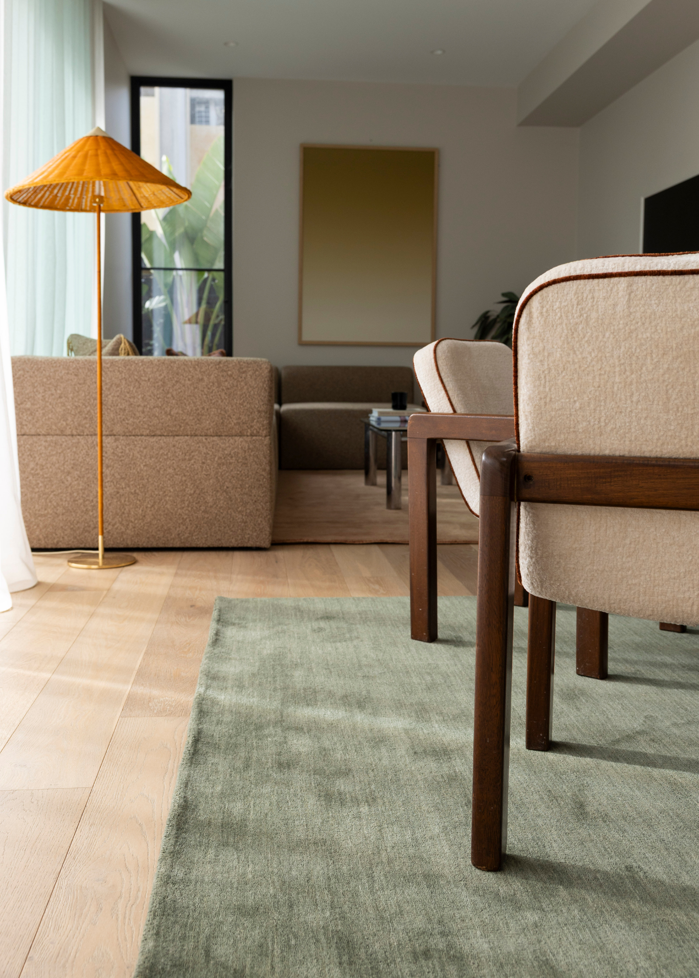 Modern living room with beige sofa, wooden table, and Wool Texture Green Rug