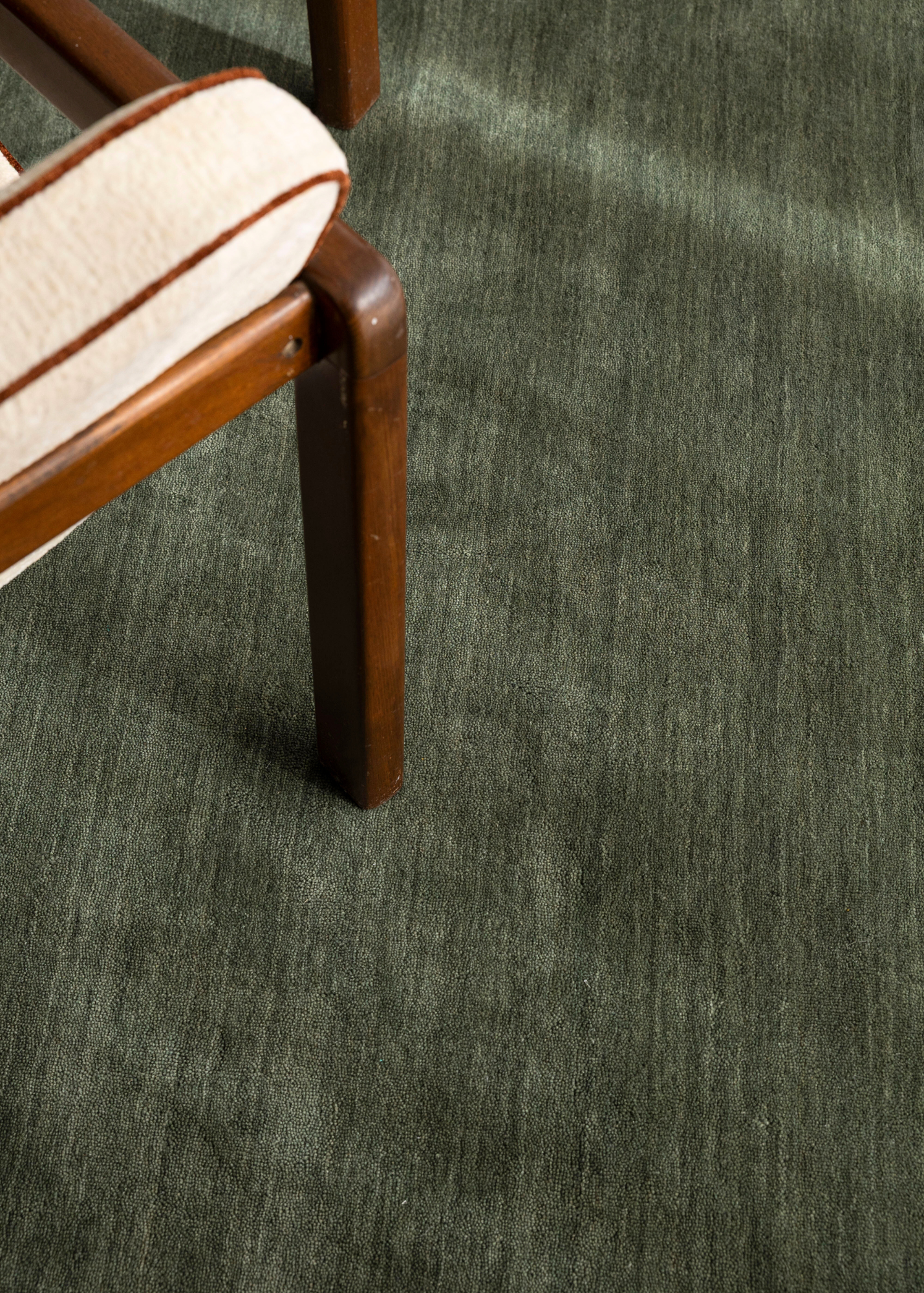 Close-up of a chair leg on Wool Texture Green Rug