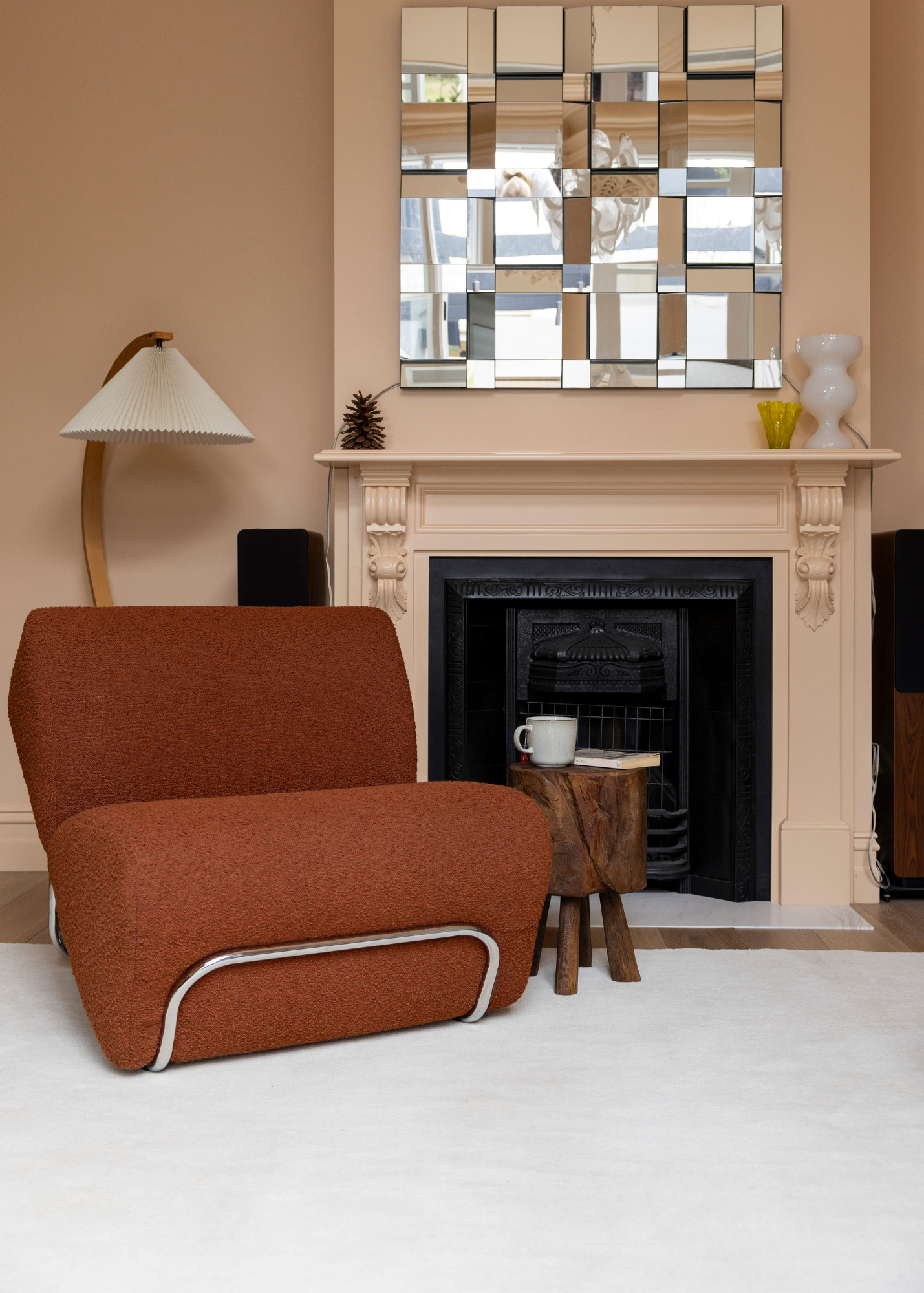 Burnt Orange armchair in a living room with a fireplace and mirror on Wool Texture Milk Cream Rug